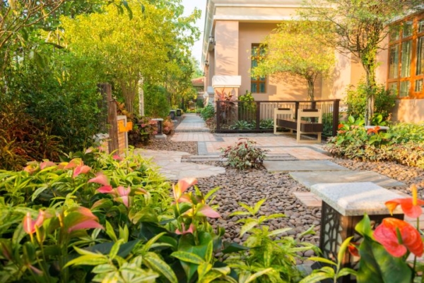 Man erkennt einen schönen Vorgarten mit einem Steinweg zum Haus