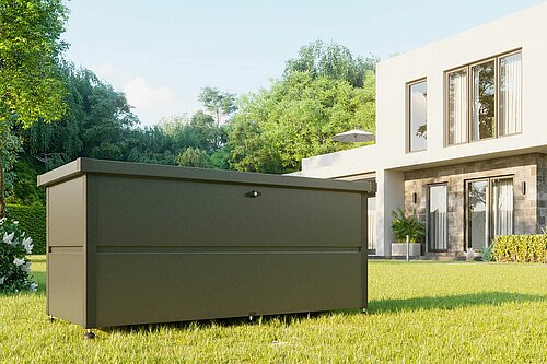 Gartenbox aus Stahl in anthrazit mit Schloss steht in einem Garten vor einem modernen Einfamilienhaus
