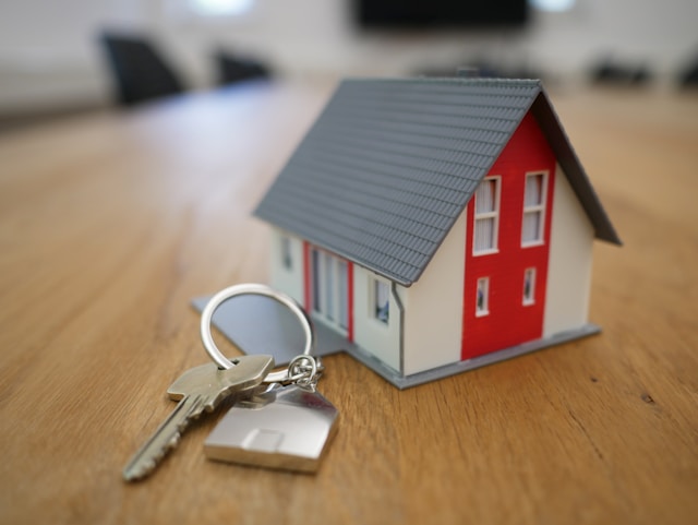Schlüsselbund mit kleinem Haus auf Tisch