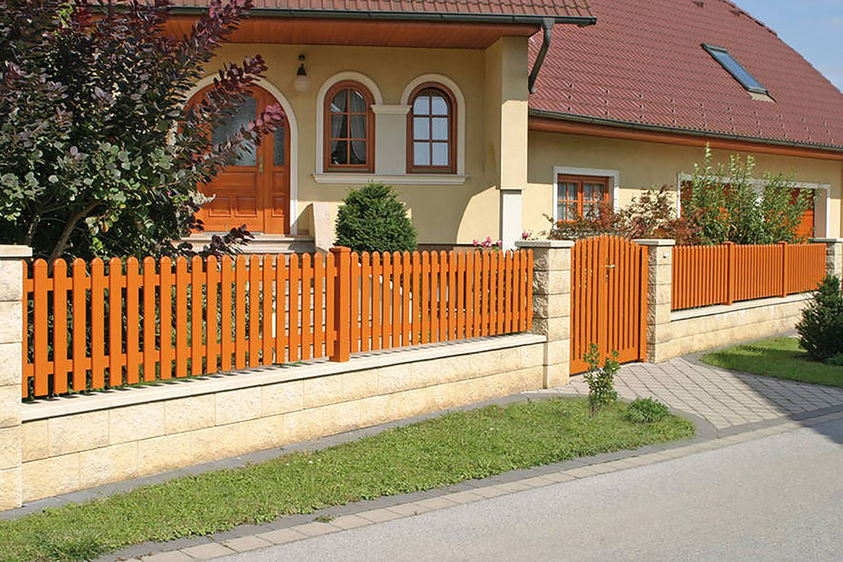 Traditioneller Zaun aus Aluminium in Holz Optik mit Gartentuer als Einfahrt vor gelbem Haus