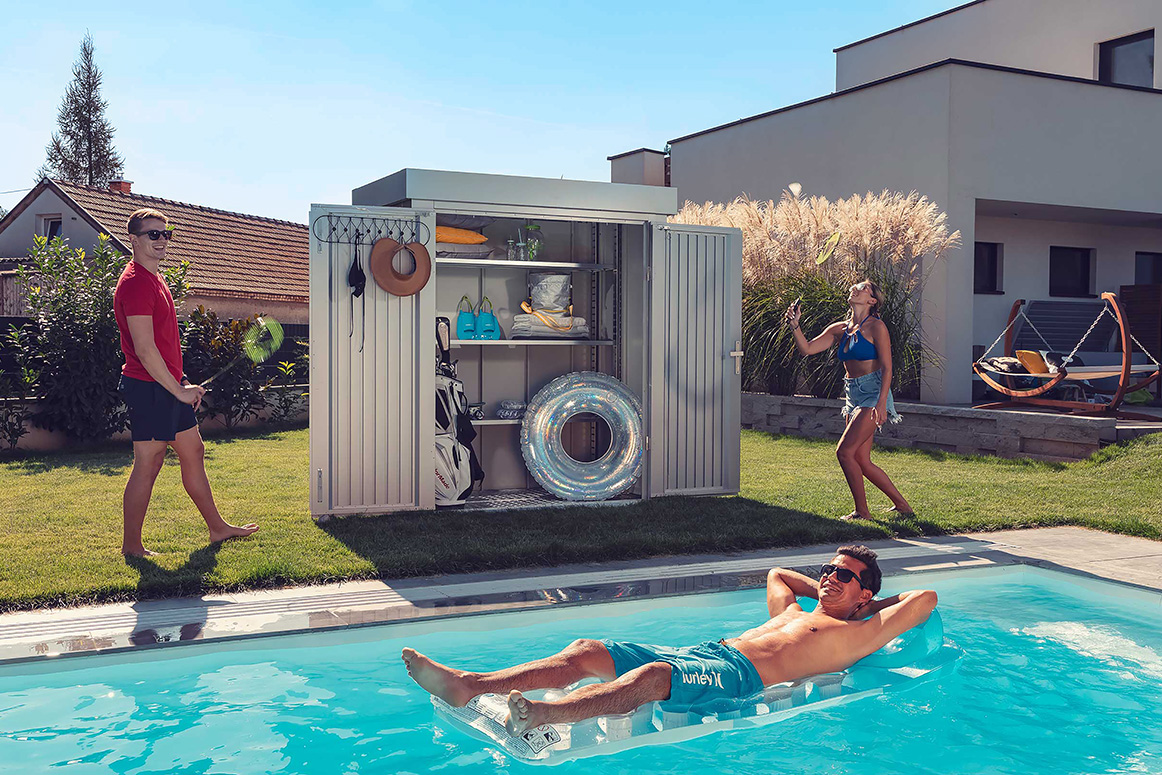 modernes geraetehaus mit doppelwandiger tuer fuer stauraum im garten mit pool