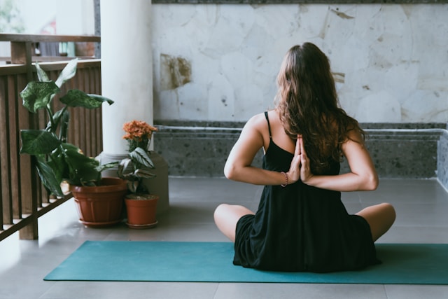 Frau macht Yoga auf dem Balkon